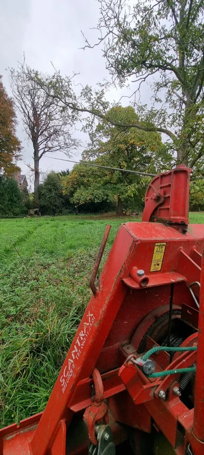 Treuil forestier sur tracteur relié à un arbre par un câble