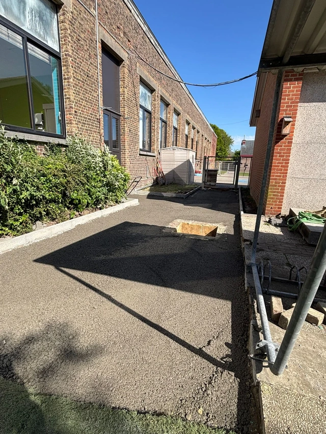 Une étape du chantier le long du bâtiment scolaire.