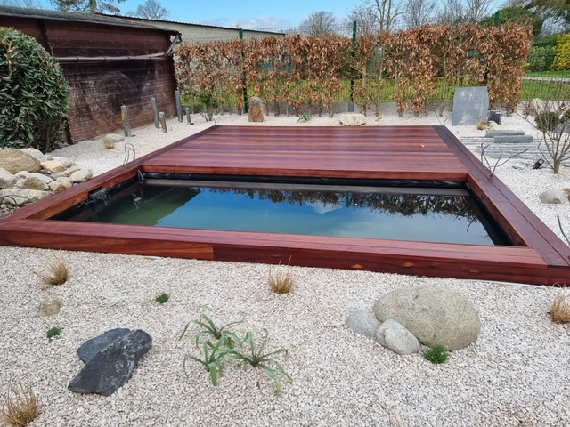 Le bassin à poissons et son habillage en padouk dans l’aménagement minéral.