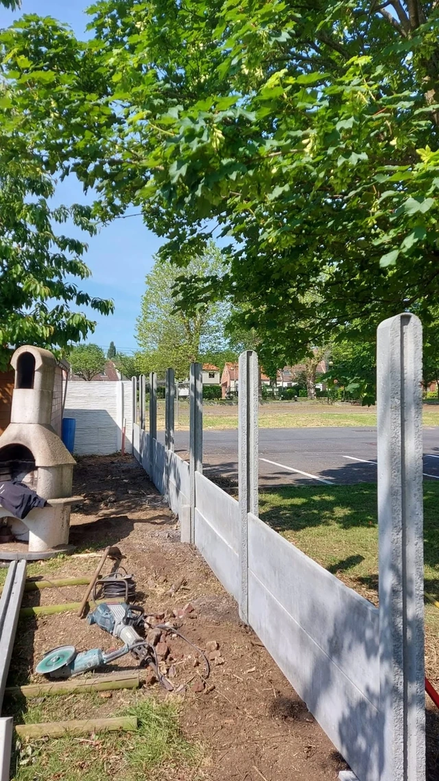 La mise en place de la clôture et du parterre bas, réalisés avec les mêmes éléments en béton.
