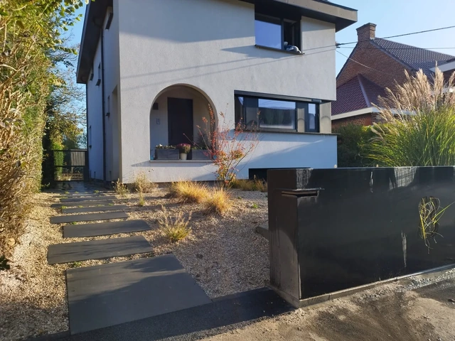 Une allée aux lignes modernes en accord avec la façade.
