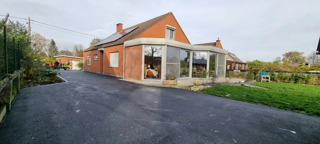 À Irchonwelz, des abords en asphalte autour de la maison.