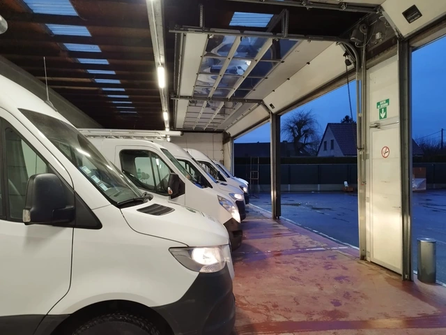 Les véhicules utilitaires stationnés à l’intérieur du dépôt.