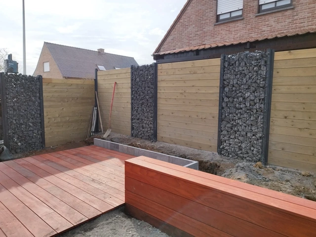 Le banc en bois marque la séparation entre la terrasse et le parterre.