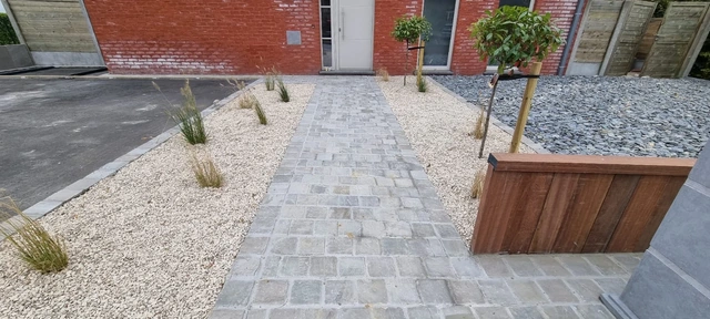 L’allée centrale en pavés Kandla, accompagnée de petits parterres.