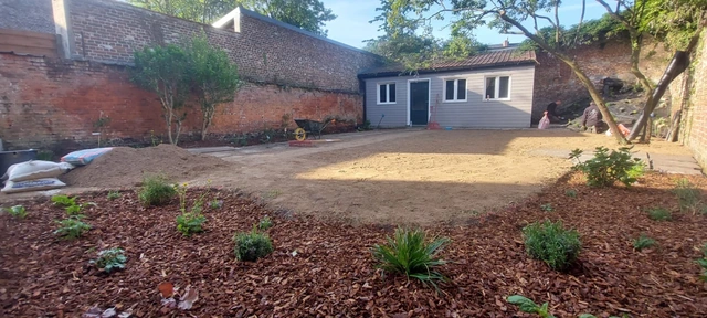 Le terrain préparé et les parterres en cours de réalisation avant la pose du gazon.