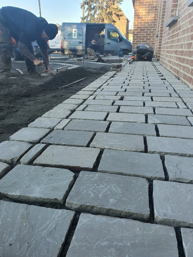 L’alignement des pavés rectangulaires pendant leur mise en place.