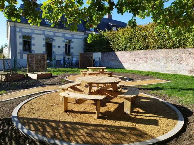 Une table de pique-nique sur son aire circulaire en dolomie.