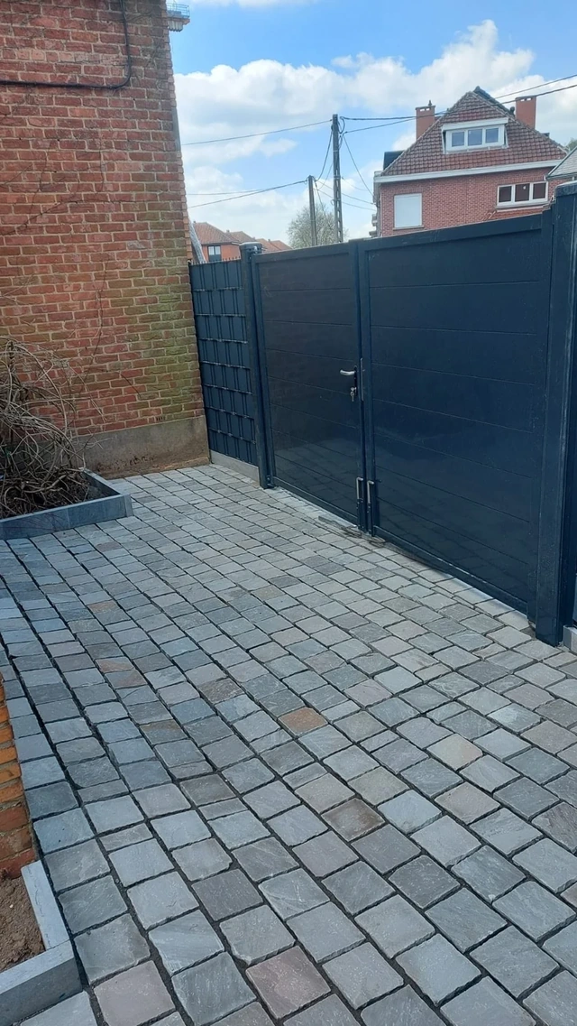 Le portail anthracite complète l’accès pavé à la propriété.