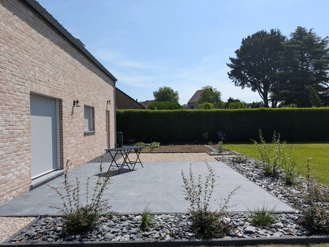 La terrasse en céramique et le petit parterre à ses abords.