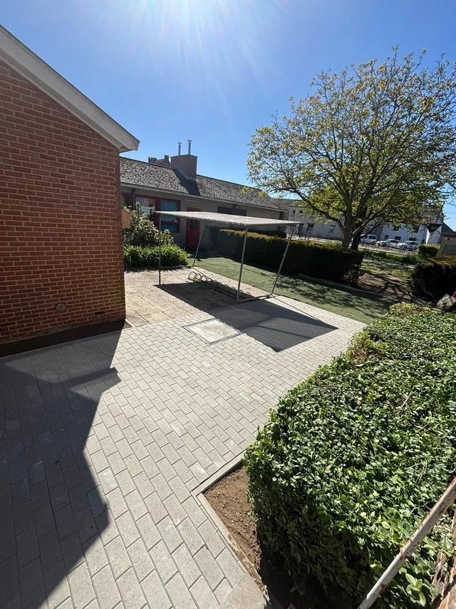 Le passage pavé longe les espaces de plantation.
