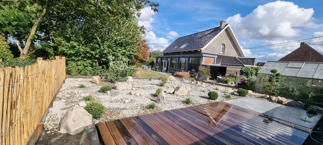 La terrasse en bois exotique réalisée par notre équipe, accompagnée de plantations sur gravier.
