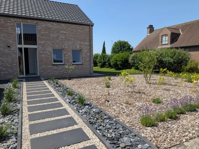 L’allée en dalles et le parterre minéral accompagnent l’entrée de la maison.