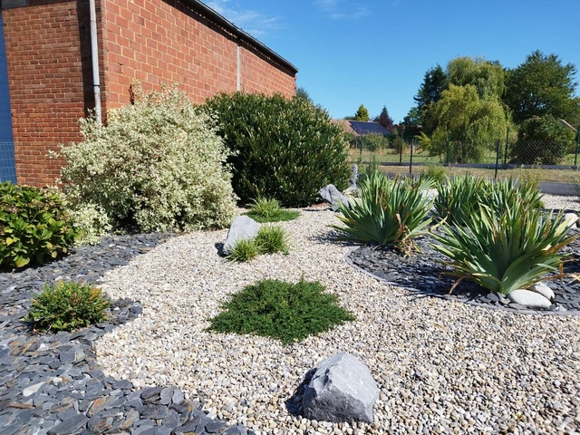 Les pierres décoratives et les végétaux rythment le parterre.