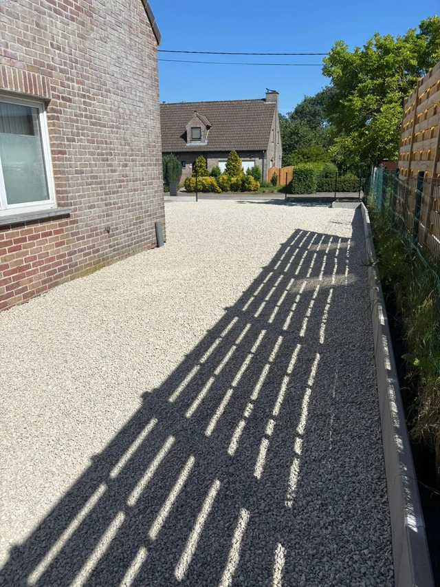Le passage en gravier longe la maison jusqu’à l’entrée.