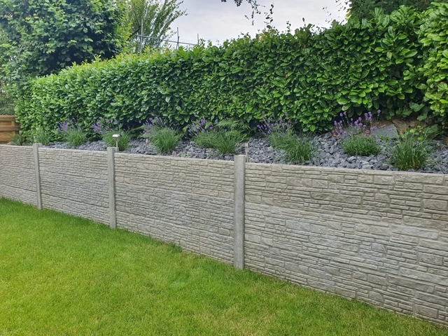 La retenue de terre en panneaux de béton longe le jardin.