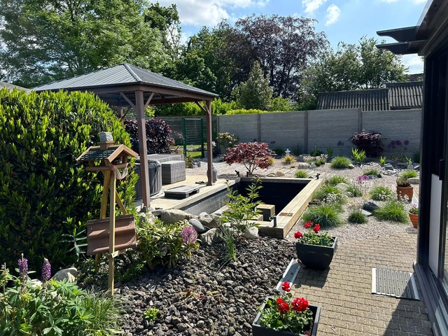 Le jardin vu depuis la maison, avec la pergola ajoutée par le client.