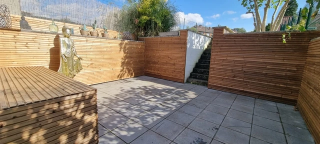 Un habillage mural en bois pour réchauffer une terrasse.
