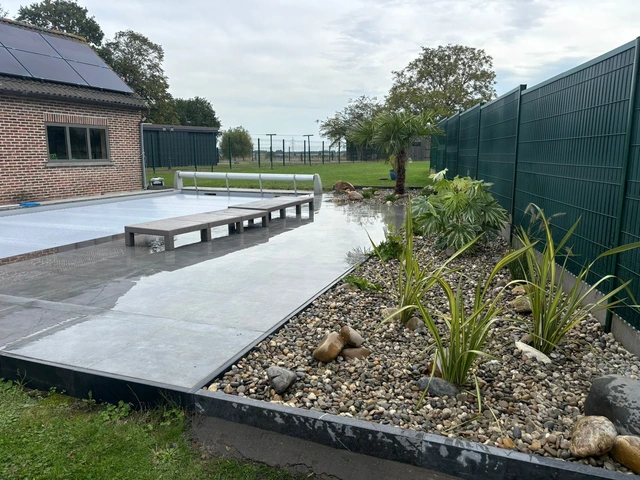 Les parterres exotiques accompagnent la terrasse en céramique et son espace de détente.