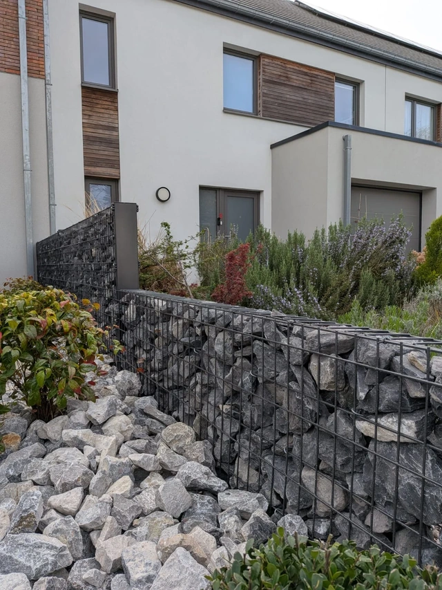 Détail des gabions remplis de pierres et des plantations du parterre.