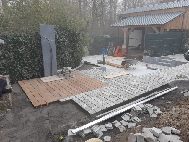 La terrasse en bois et la pierre dressée pour accueillir la douche.