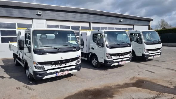 Les trois nouveaux véhicules-bennes FUSO devant le dépôt.