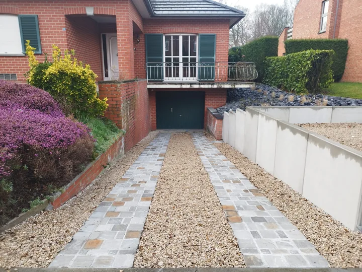 La descente de garage entre pavés, gravier et soutènement.